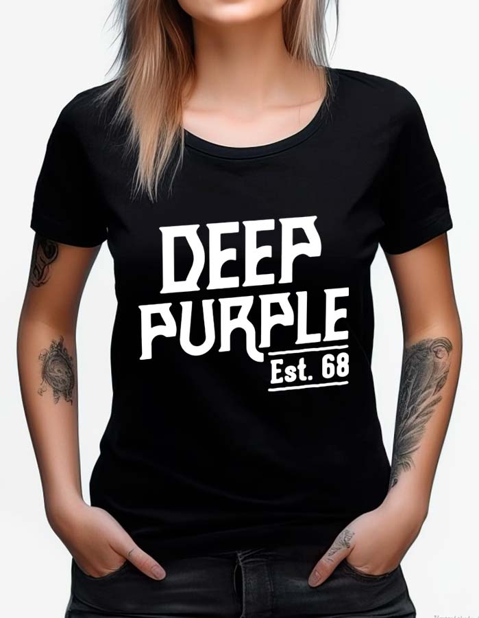 Osoba ma na sobie czarną koszulkę damską DEEP PURPLE "EST.68" z pogrubionym białym napisem, ręce w kieszeniach i widoczne tatuaże na ramieniu.