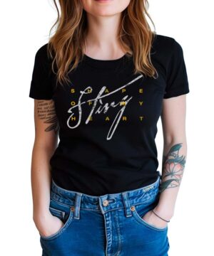 Czarna koszulka muzyczna STING "Shape of my heart" zakładana przez kobietę, widoczne tatuaże na rękach i niebieskie jeansy.