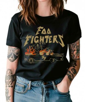 Osoba z tatuażami na obu ramionach i w niebieskich dżinsach ma na sobie czarną koszulkę damską FOO FIGHTERS "Joyride" z grafiką płonącego samochodu.