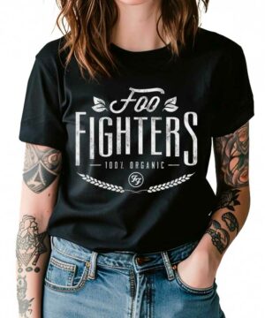 Osoba ubrana w czarną koszulkę FOO FIGHTERS "Organic" i dżinsy, z tatuażami na obu ramionach.