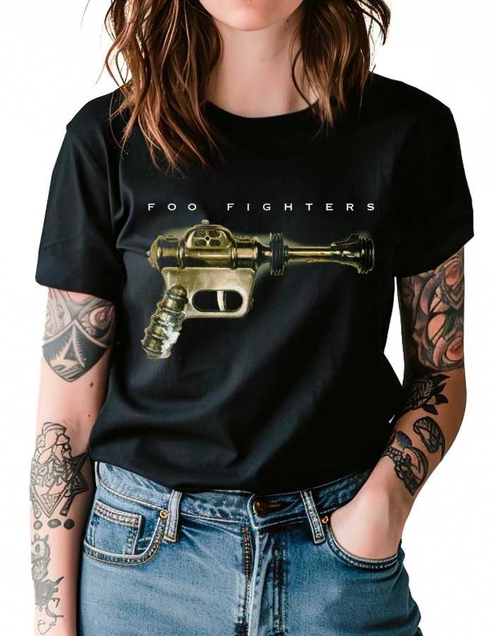 tshirt-koncertowy-muzyczny-damski-foo-fighters-ray-gun-classic Osoba ubrana w czarną koszulkę damską FOO FIGHTERS "Ray Gun Classic" z grafiką ray gun z przodu; tatuaże widoczne na obu ramionach.