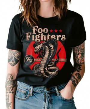 Osoba ubrana w czarną koszulkę damską FOO FIGHTERS "Snake" z dużą grafiką zwiniętego węża na czerwonym okrągłym tle, z tatuażami widocznymi na obu ramionach.
