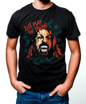 Osoba nosząca koszulkę FOO FIGHTERS "Just play the drums" - czarną koszulkę z warczącą twarzą i pogrubionym czerwono-pomarańczowym napisem "Just Play The Drums".