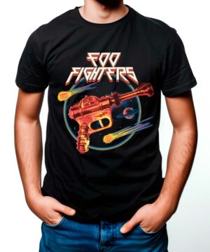 Osoba nosząca koszulkę męską FOO FIGHTERS "Ray gun" w kolorze czarnym, prezentującą żywy wzór o tematyce kosmicznej z retro pistoletem promieniowym, planetami i kometami.