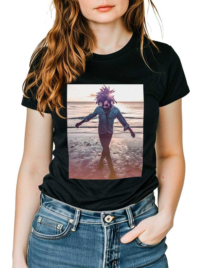 tshirt-muzyczny-czarny-damski-lenny-kravitz-raise-vibration Czarna koszulka muzyczna LENNY KRAVITZ "Raise Vibration" z nadrukiem osoby spacerującej po plaży o zachodzie słońca.