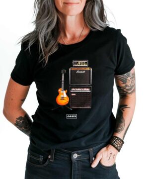 Czarna koszulka muzyczna OASIS "DM Guitar" z nadrukiem gitary, wzmacniaczy i logo oasis, noszona przez osobę z długimi włosami.