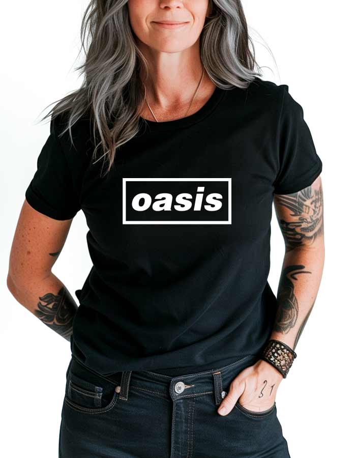 tshirt-muzyczny-damski-czarny-oasis-logo Czarna koszulka muzyczna OASIS z białym logo "oasis" w prostokącie, noszona przez osobę z siwymi włosami i tatuażami.