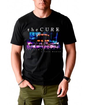Mężczyzna w czarnej koszulce THE CURE "The show of a lost world" z kolorowym nadrukiem, do tego oliwkowe spodnie cargo.