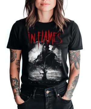 Czarna koszulka IN FLAMES "In the dark" z nadrukiem zakapturzonej postaci i drzewa na przodzie, noszona przez wytatuowaną osobę.