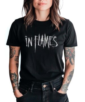 Czarna koszulka muzyczna IN FLAMES "Sign" z białym, postarzanym logo IN FLAMES. Osoba stoi z rękami w kieszeniach.