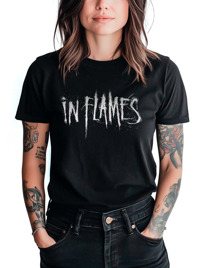 tshirt-muzyczny-damski-czarny-in-flames-sign Czarna koszulka muzyczna IN FLAMES "Sign" z białym, postarzanym logo IN FLAMES. Osoba stoi z rękami w kieszeniach.
