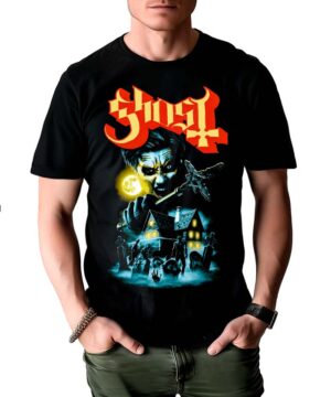 Mężczyzna nosi koszulkę męską GHOST "By the cemetery": czarny t-shirt z czerwonym napisem "Ghost" nad złowieszczą twarzą, księżycem w pełni, nawiedzonym domem i sylwetkami zombie lub ghuli.