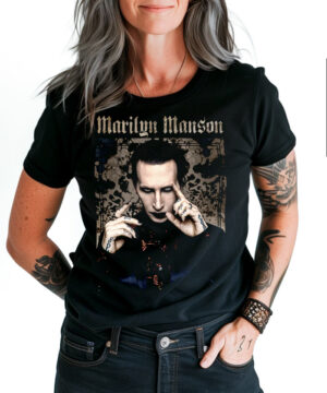 Czarna koszulka MARILYN MANSON "Pointing", osoba stoi z ręką w kieszeni, widoczne tatuaże i bransoletki na obu ramionach.