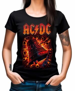 Kobieta w koszulce damskiej ACDC "Hells Bells Red" - czarnej koszulce z ognistym logo AC/DC i grafiką dzwonu - stoi z rękami w kieszeniach dżinsów.