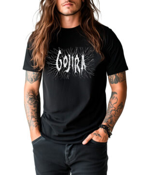 Osoba z długimi brązowymi włosami i tatuażami ma na sobie czarną koszulkę GOJIRA "Fortitude" i czarne spodnie, stojąc na białym tle.