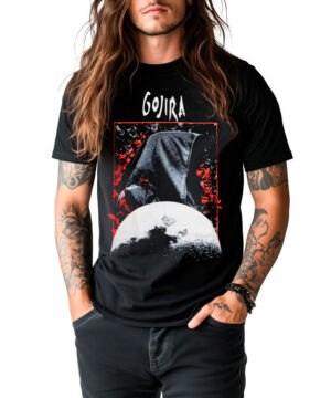 Osoba z długimi włosami i tatuażami ubrana w czarną koszulkę GOJIRA "Grim moon" stoi z rękami w kieszeniach na białym tle.