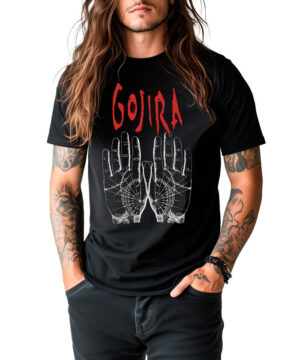 Osoba z długimi włosami i tatuażami nosi koszulkę GOJIRA "Hands", przedstawiającą dwie ilustrowane dłonie i pogrubiony czerwony tekst, z rękami swobodnie w kieszeniach.