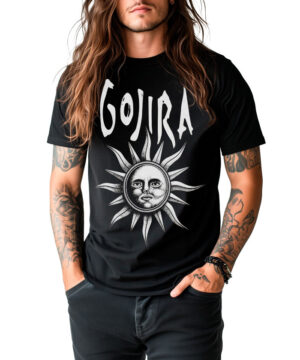 Długowłosa, wytatuowana osoba nosi koszulkę męską GOJIRA "Magma" z grafiką - czarny t-shirt ze stylizowaną twarzą słońca - stojąc z rękami w kieszeniach na białym tle.