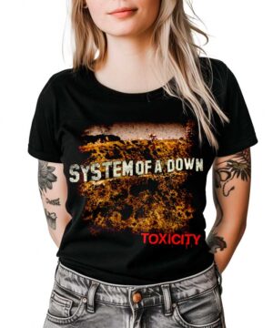 Kobieta w czarnej koszulce SYSTEM OF A DOWN "Toxicity" z przetartym nadrukiem, stoi z rękami wzdłuż ciała.
