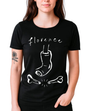 Kobieta ma na sobie koszulkę damską FLORENCE AND THE MACHINE "Brokenbone" - czarny t-shirt z napisem "Florence" nad grafiką przedstawiającą nogę w gipsie stąpającą po dwóch złamanych kościach; na lewym przedramieniu ma tatuaż słonecznika.