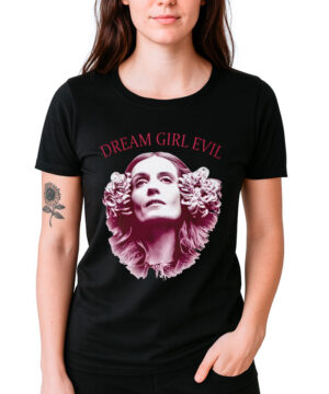 Kobieta ma na sobie czarną koszulkę FLORENCE AND THE MACHINE "Dream Girl Evil" z twarzą kobiety otoczoną kwiatami i napisem DREAM GIRL EVIL powyżej. Na jej lewym przedramieniu widoczny jest tatuaż słonecznika.
