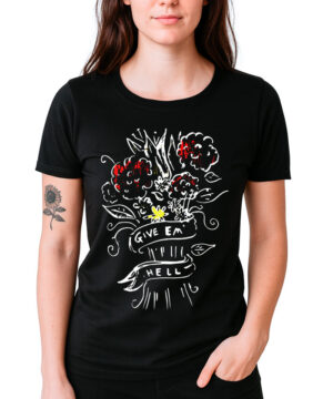 Kobieta nosi koszulkę damską FLORENCE AND THE MACHINE "Give'em Hell", czarny t-shirt z kwiatową grafiką; na lewym przedramieniu ma tatuaż słonecznika.