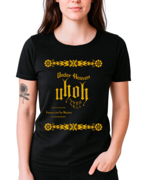 Osoba nosi koszulkę damską FLORENCE AND THE MACHINE "Under heaven" - czarną koszulkę z żółtym tekstem i ozdobnymi żółtymi wzorami.