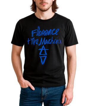 Mężczyzna stoi z jedną ręką w kieszeni, ubrany w koszulkę męską z grafiką FLORENCE AND THE MACHINE "Hand drawn logo" - czarny t-shirt z niebieskim tekstem i geometrycznymi symbolami.