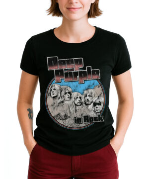 Osoba stoi na białym tle, ręce w kieszeniach, ubrana w czarną koszulkę damską DEEP PURPLE "Rushmore in rock" z ilustracjami twarzy członków zespołu na skale.