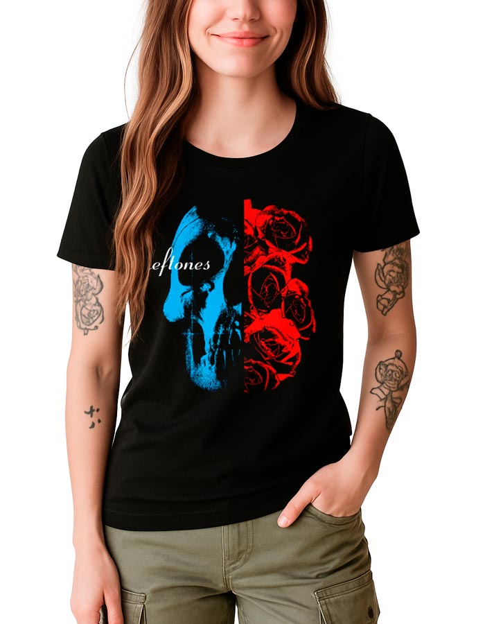 Kobieta nosi czarną koszulkę damską DEFTONES "Rose Skull" z grafiką niebieskiej czaszki i czerwonych róż, z jedną ręką w kieszeni.