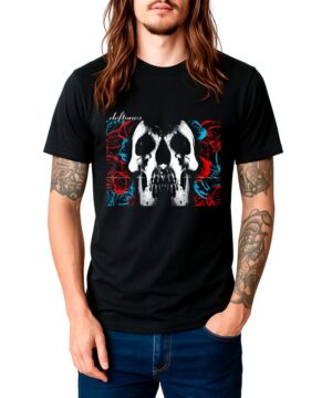 Osoba nosząca koszulkę DEFTONES "Skull" - czarną koszulkę z grafiką czaszki, czerwonymi i niebieskimi różami oraz napisem Deftones - stoi z jedną ręką w kieszeni.