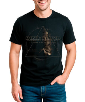 Mężczyzna w czarnej koszulce PINK FLOYD z motywem piramidy i niebieskich jeansach stoi z ręką w kieszeni, uśmiechnięty.