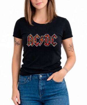 Kobieta w czarnej koszulce damskiej ACDC "Leopard logo", niebieskie jeansy, widoczne tatuaże na obu ramionach.