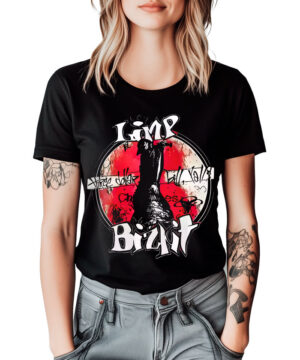 Blondynka z tatuażami ubrana w czarną koszulkę LIMP BIZKIT "Vintage" z czerwono-białą grafiką, w połączeniu z jasnoszarymi dżinsami.