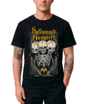 Mężczyzna ubrany w czarną męską koszulkę HOLLYWOOD VAMPIRES „Conjoined Skeleton” z grafiką przedstawiającą trzy szkielety, ozdobne wzory oraz żółte napisy: Cooper, Depp i Perry. Koszulka w kolorze czarnym, idealna dla fanów zespołu.