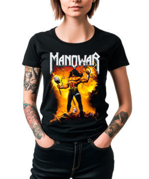 Kobieta w czarnej damskiej koszulce MANOWAR „Gods and Kings” z kolorowym, fantastycznym motywem wojownika z przodu; krótki rękaw, klasyczny krój, widoczne wytatuowane ramiona, modelka stoi z rękami w kieszeniach.