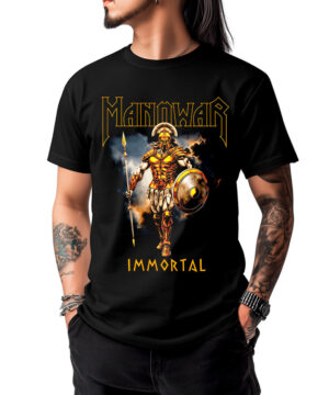 Mężczyzna w czarnej koszulce MANOWAR „Immortal” z kolorową grafiką przedstawiającą złotego wojownika w zbroi, trzymającego włócznię i tarczę, na tle płomieni.